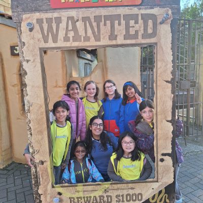 The Brownies and Guides gathered inside the Wanted frame and smiling.