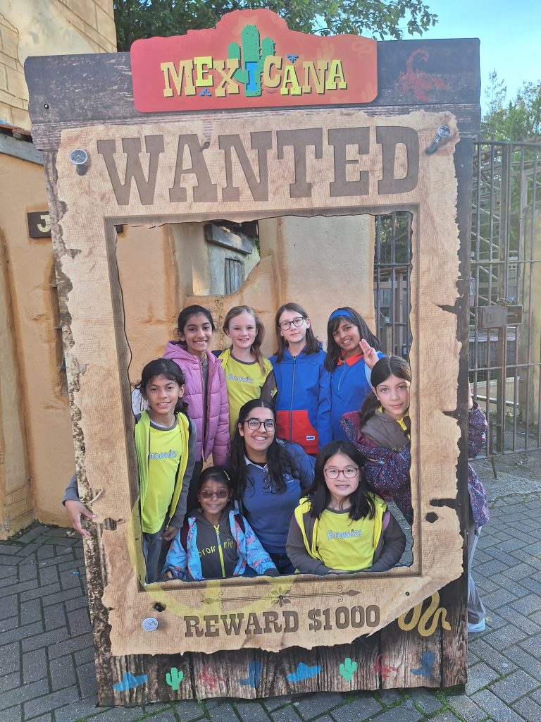 The Brownies and Guides gathered inside the Wanted frame and smiling.